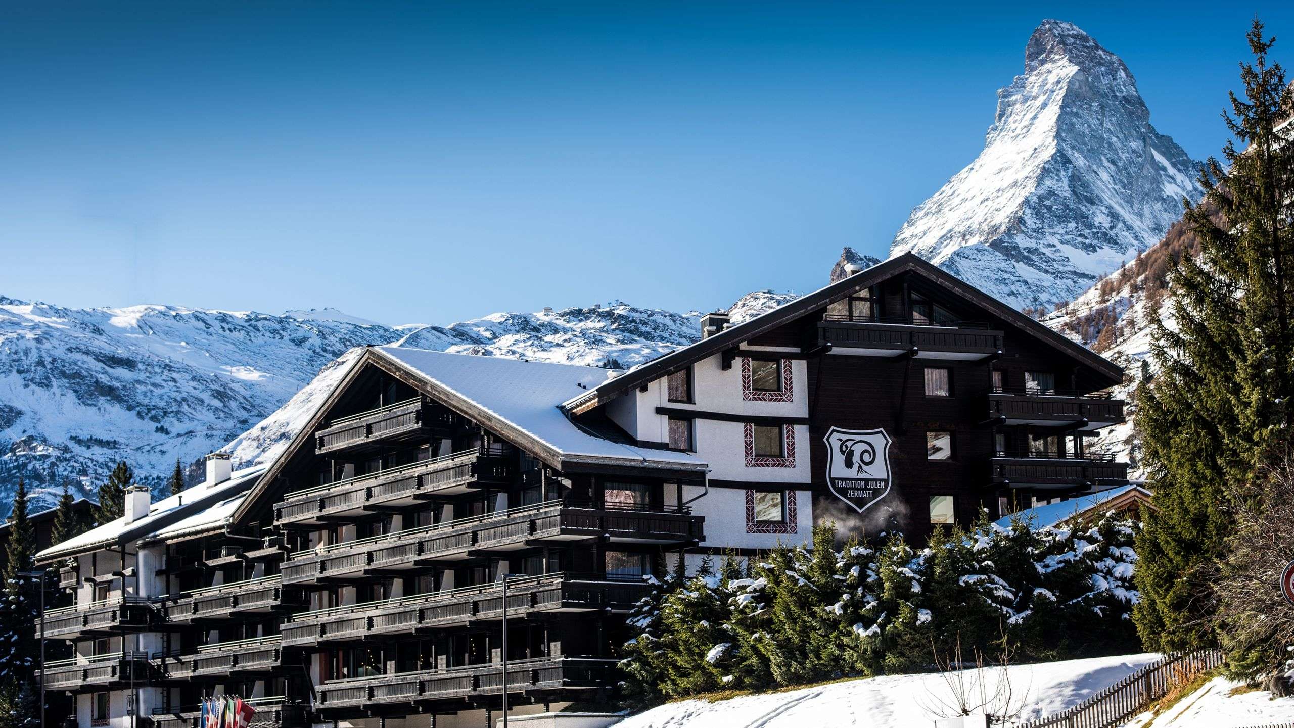 Schneebedecktes Hotelgebäude in den Alpen vor dem berühmten Matterhorn.