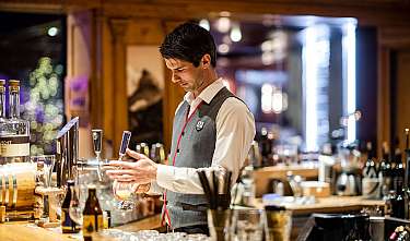 Un barman sert une boisson dans un bar élégant.
