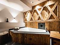 Modernes Badezimmer mit freistehender Badewanne, Holzvertäfelung und dunkler Steinablage.