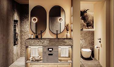 Stilvolles Badezimmer mit zwei runden Spiegeln, steinerner Waschtisch und separater Toilette.