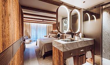 Chambre d’hôtel moderne avec lit double, double vasque et éléments en bois chaleureux