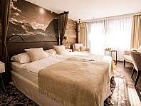 Modern eingerichtetes Hotelzimmer mit Doppelbett, großen Fenstern und Sitzecke.