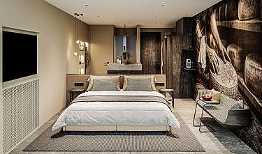 Modernes Schlafzimmer mit Doppelbett, dunkler Akzentwand, Sitzbank und Hängeleuchten.