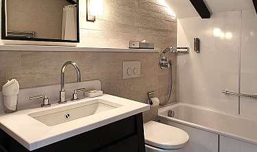 Modernes Badezimmer mit Waschbecken, Badewanne, Dusche und Spiegel