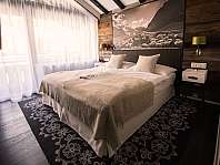 Chambre moderne avec lit double, mur en bois, rideaux et tapis à motif