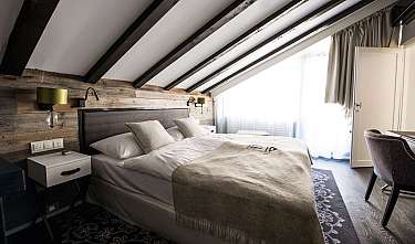 Modern bedroom with sloping ceiling, double bed and bright window