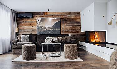Salon moderne avec canapé, table basse, cheminée et mur en panneaux de bois.