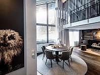 Modern loft living room with a round dining table, large window front and gallery level.