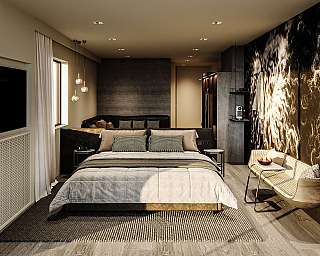 Modernly furnished bedroom with bed, bench and warm pendant lights.