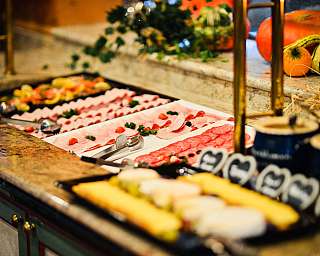 Buffet with sliced fruit, dessert plates and autumn decorations
