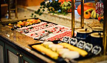 Buffet avec charcuterie, légumes, citrouilles et pinces de service