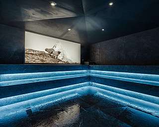 Douche moderne et sombre avec éclairage LED bleu et fresque murale avec des moutons.