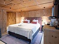 Chambre lumineuse avec lit double, lambris en bois et accents décoratifs violets