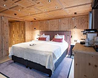 Chambre lumineuse avec lit double, lambris en bois et coin thé.