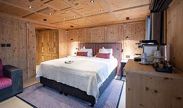 Chambre lumineuse avec lit double, revêtement en bois et coin petit-déjeuner