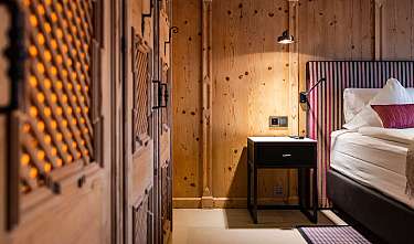 Chambre à lambris en bois avec lit, table de chevet et éclairage chaleureux
