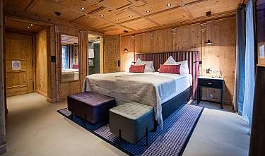 Une chambre à coucher élégamment aménagée avec un lit double, des murs en bois et une décoration moderne.
