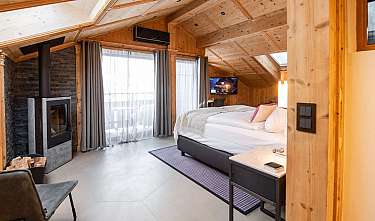 Chambre à coucher moderne en bois avec lit, cheminée et grandes fenêtres