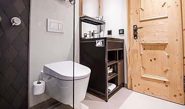 Salle de bains moderne avec WC suspendu, porte en bois, douche noire et meuble sous-vasque