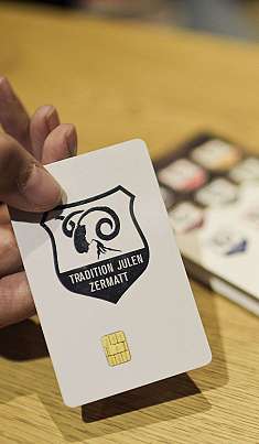 Une main tient une carte blanche avec une puce sur une table en bois