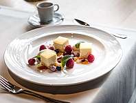 Dessert mit Beeren und Minze auf großem weißem Teller im Restaurant