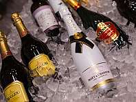 Mehrere Champagnerflaschen liegen in zerstoßenem Eis in einer Kühlwanne.