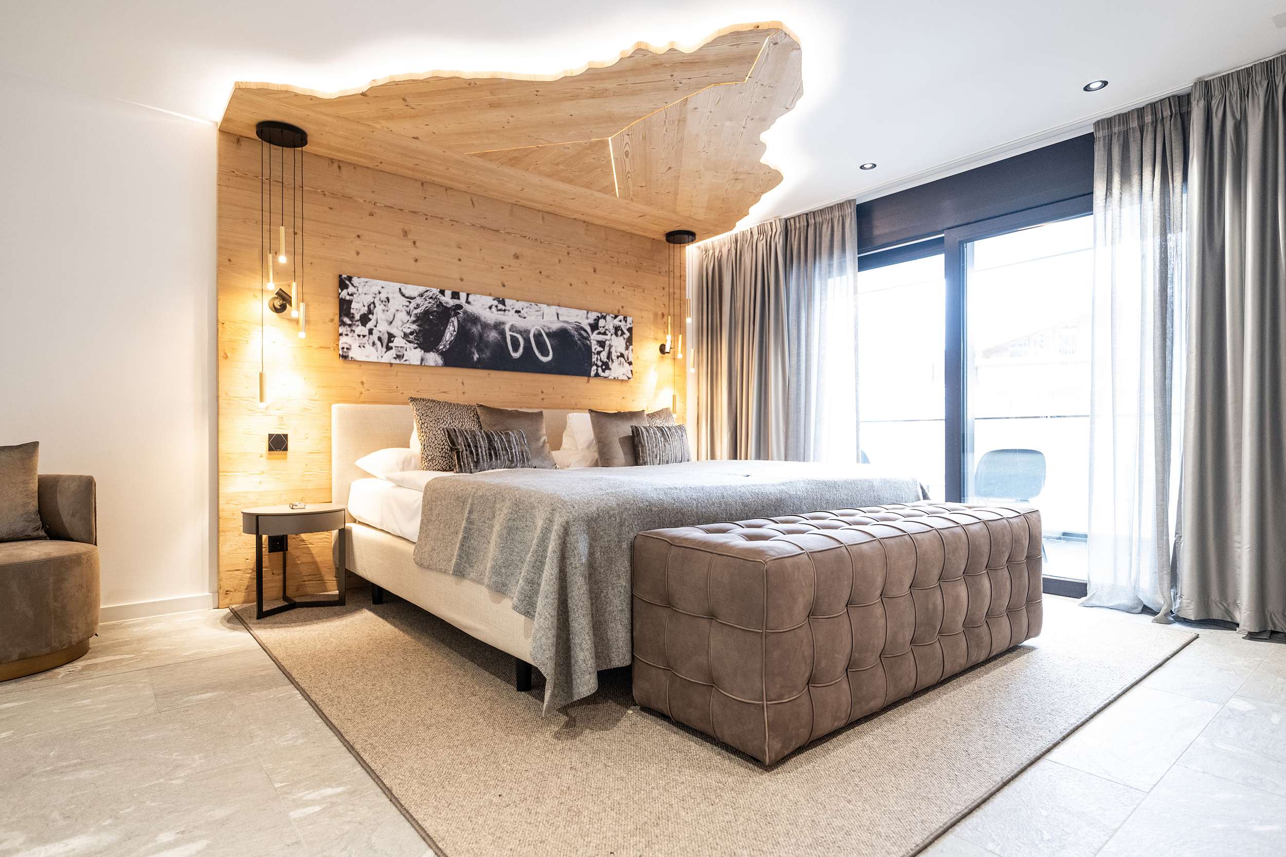 Chambre à coucher moderne avec lit, plafond en bois, façade vitrée et pouf de siège rembourré.