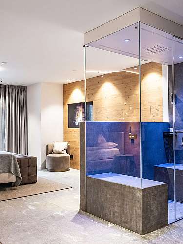 Modernes Schlafzimmer mit integrierter Glasdusche und freistehendem Badbereich