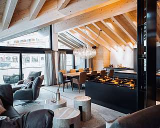 Moderne Wohnküche mit hoher Holzdecke, großen Fenstern und Esstisch