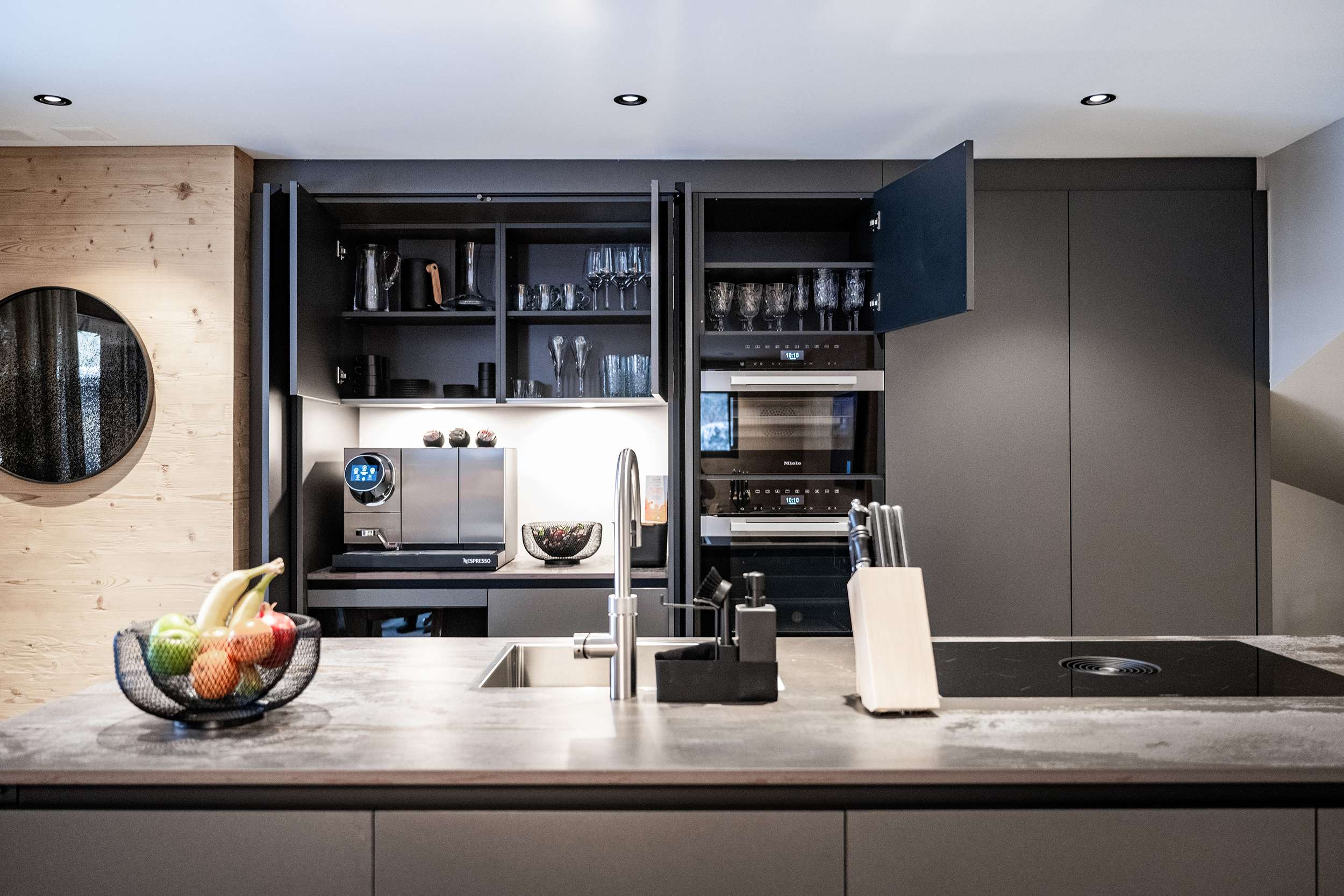 Cuisine moderne avec îlot de cuisson, placards ouverts et machine à café