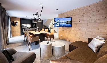 Salon moderne avec table à manger, canapé, télévision murale et lambris en bois