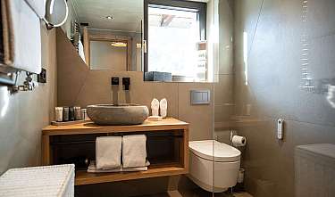 Modernes Badezimmer mit Holzwaschtisch, Steinwaschbecken, Spiegel und Toilette