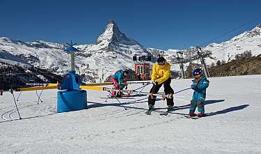 Personnes lors d’un entraînement de ski sur une piste enneigée avec un décor de montagne